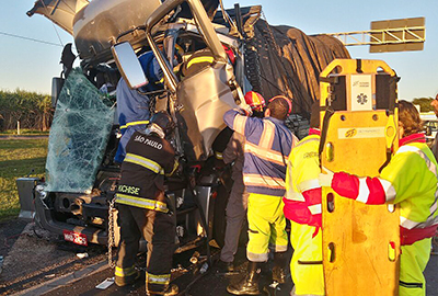 Bombeiros e socorristas trabalham para retirar o motorista de um dos caminhões, que ficou preso nas ferragens