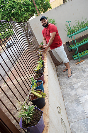 O segurança aproveita o espaço cimentado para cultivar plantas em vasos