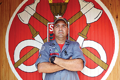 O bombeiro na frente de um de seus desenhos no quartel